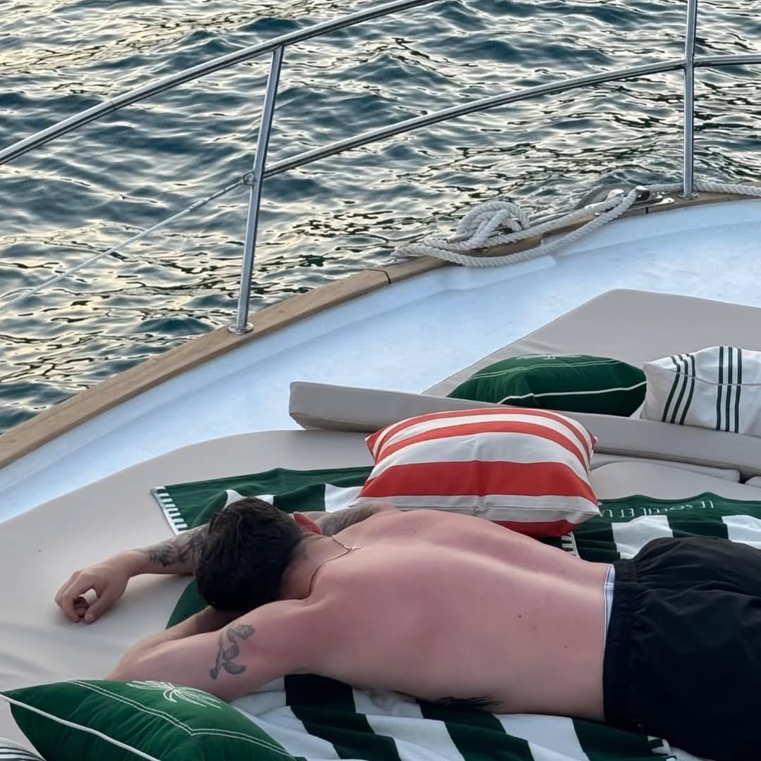 Sunbathing on deck cushions during a golden-hour cruise